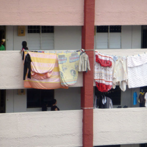Clothes hanging out to dry along the corridors of a public housing block. These long walkways function as liminal or parochial spaces, and are often seen as an extension of the domestic sphere of the home. HDB, or public housing flats house 85% of Singapore's resident population. (Photo: Laavanya Kathiravelu)