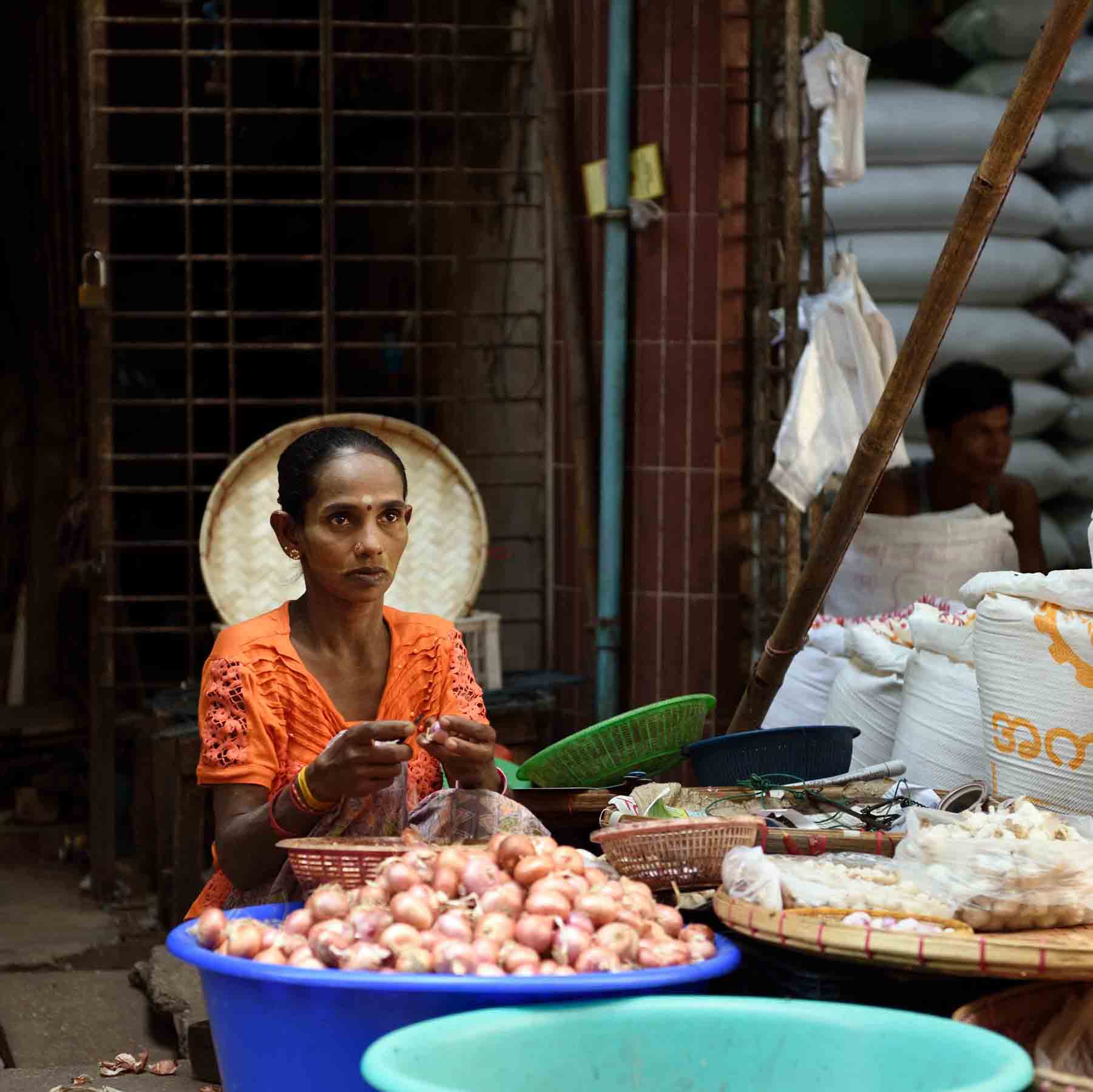 A Hindu woman of south Asian descent selling garlic and onions at a bustling morning market. During the colonial era, the British government waived ferry fees to encourage labor migration from India into Burma’s fallow delta region. Today, Yangon remains a diverse city with trade frequently divided along ethnic lines. (Photo: Naomi Hellmann)