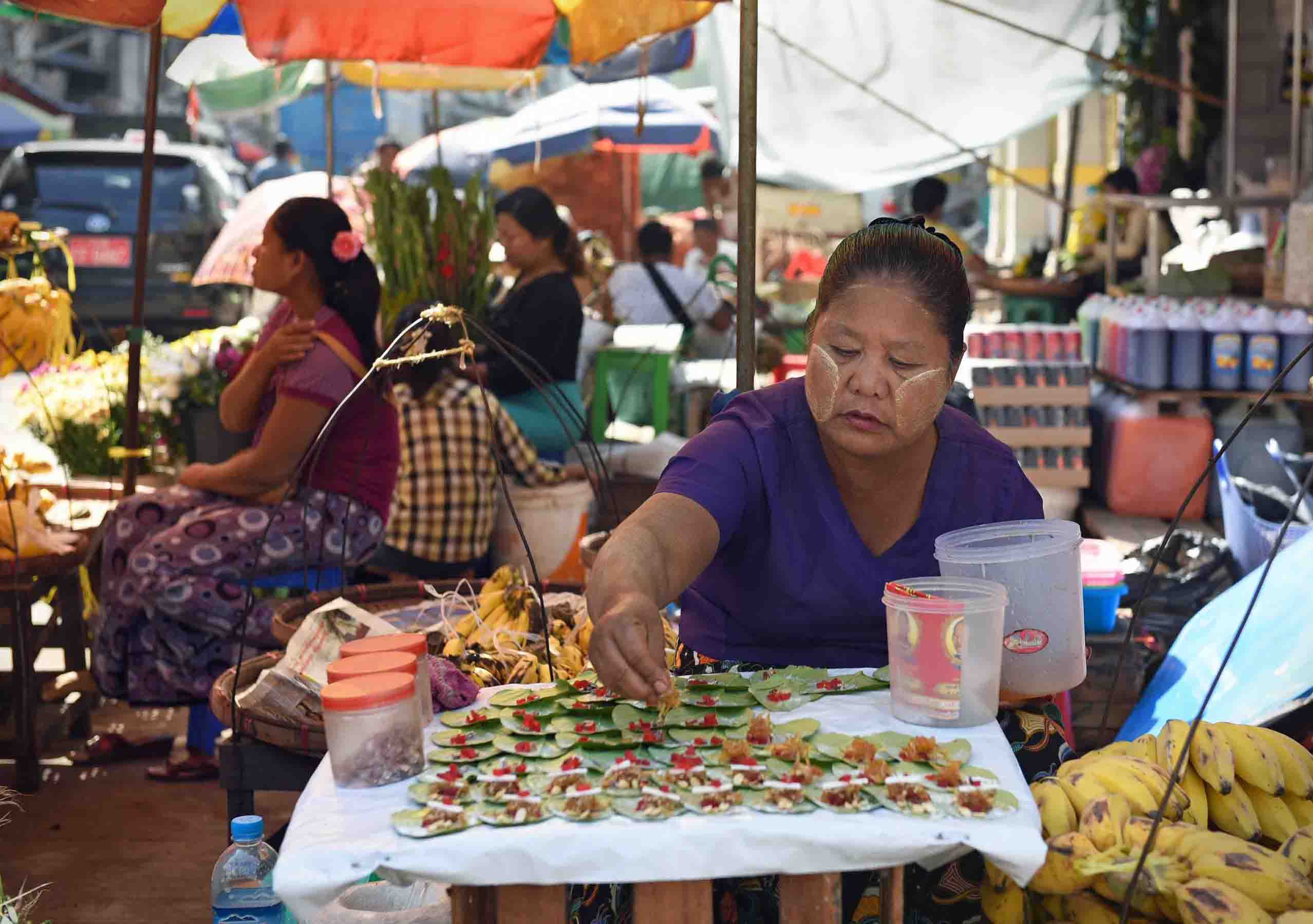 Making paan, a Burmese snack with areca nut wrapped in betel leaves. (Photo: Naomi Hellmann)