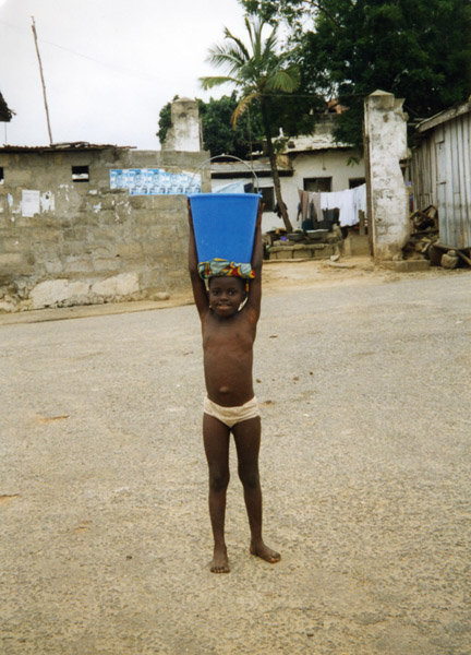 Girl carrying a bucket of water (Winneba, Ghana). (Photo: Boris Nieswand)