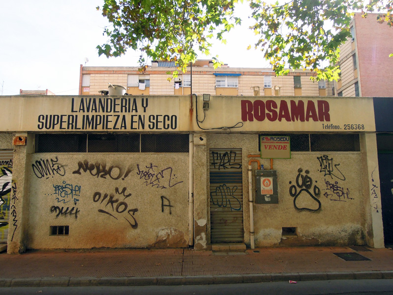 Closed shops in former commercial area with social housing blocks behind, multi-ethnic neighborhood, Murcia, Spain. (Photo: Damian Omar Martinez)